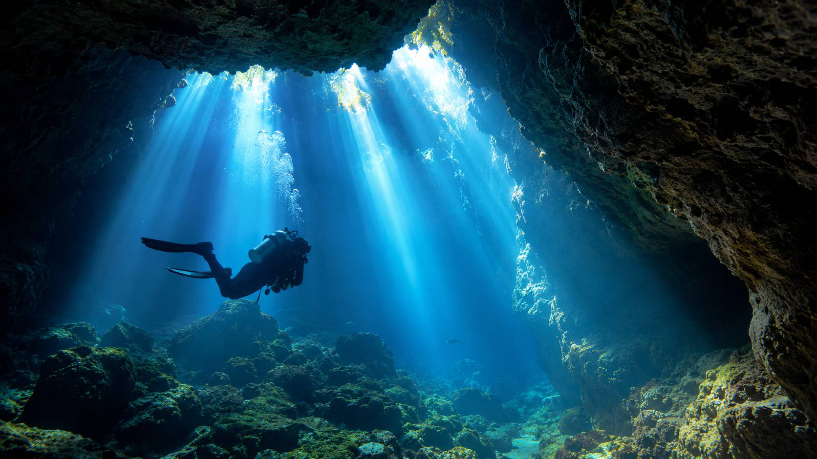 Silhouette de plongeur à contre-jour dans une grotte
