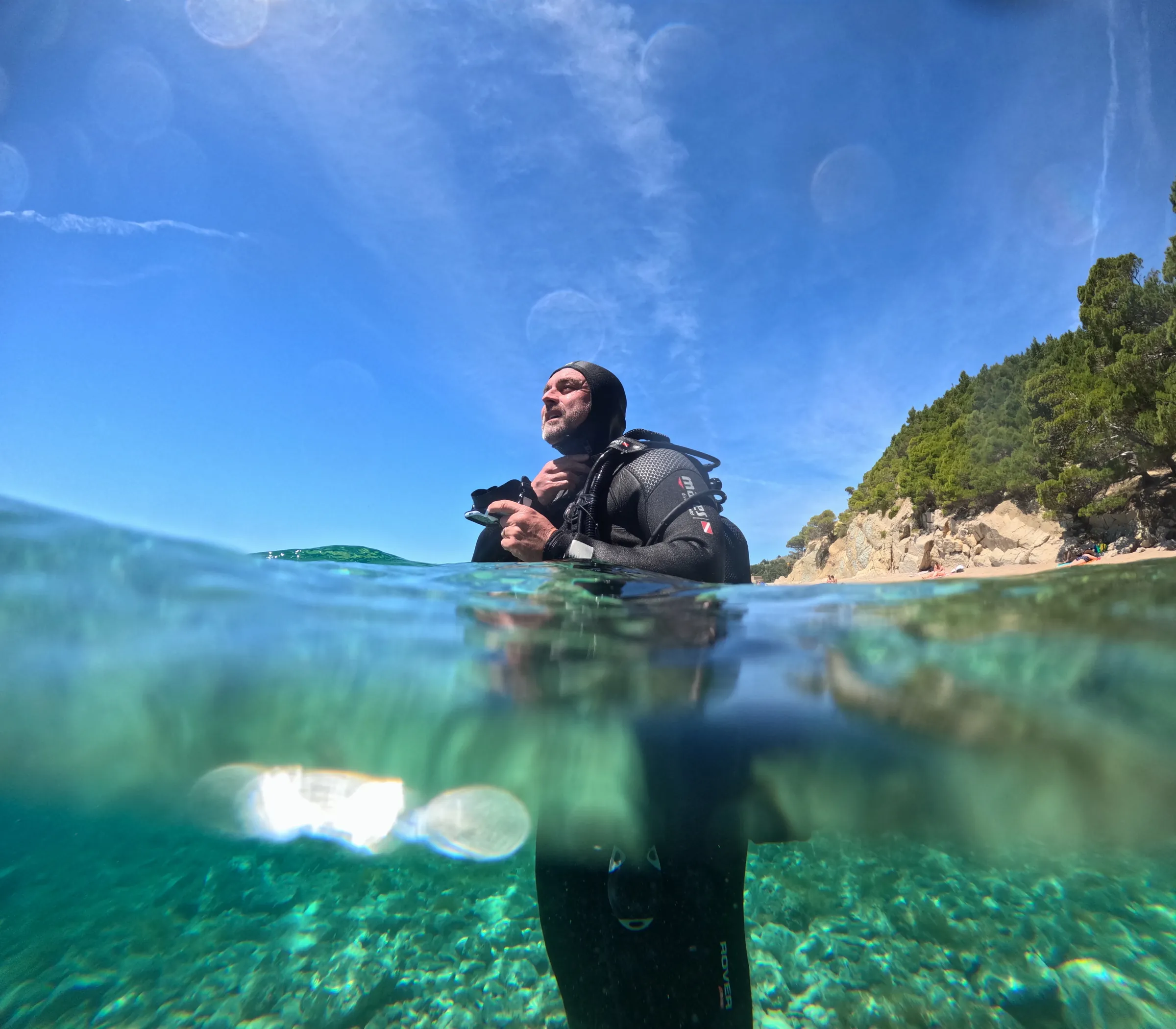 Split-level view of a diver just below the calm surface of the Adriatic